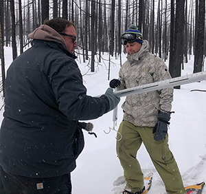 two men in snow in white forest