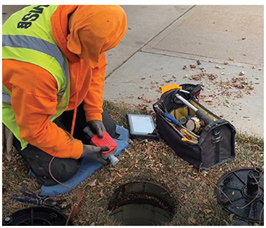 Photo of a City of Greeley worker installing a new water meter